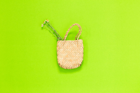 weave bag with dried flowers isolated on green backgroundの写真素材