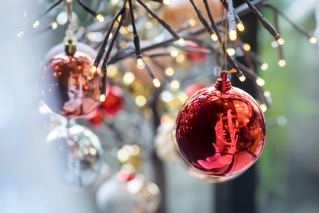 closeup red ball on christmas tree with colorful bokeh backgroundの写真素材