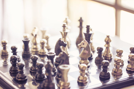black and silver chessmen on checkerboard, concept for business competition