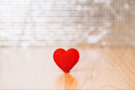 red fabric heart on wood with bokeh background, Valentine's day conceptの写真素材