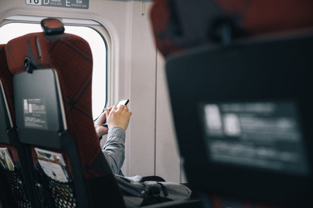 man's hand using smart phone while traveling on train 