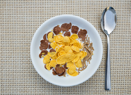 top view cornflakes and milk in white bowl for breakfastの写真素材