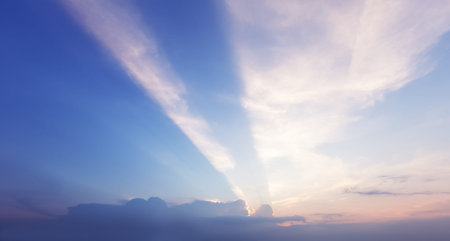 sunset behind cloud with rays in pastel sky 