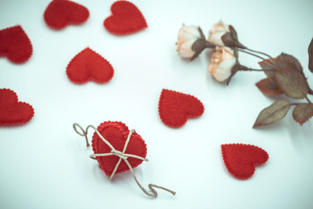 red fabric hearts and fake roses on white background, Valentine's day concept