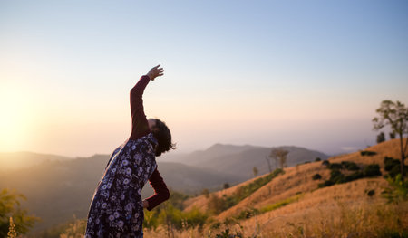back of woman stretching on top of hill in the morning, leisure and activity concept