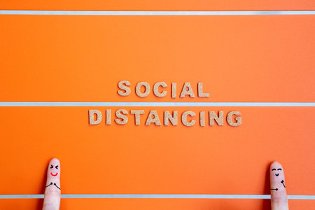social distancing word with fingers face painting on orange background, coronavirus prevention...