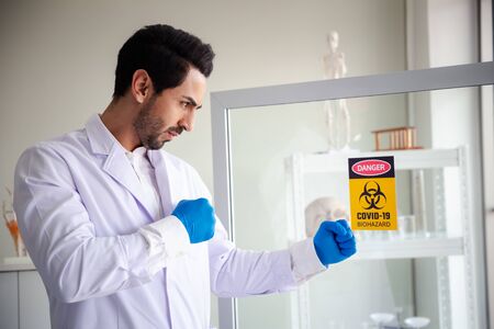 man acts as fighting to biohazard virus warning signの写真素材