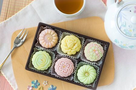 colorful pastel snow skin mooncakes with hot tea, chinese mid autumn festival foodの写真素材