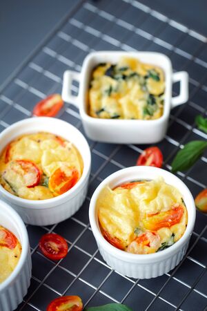 egg muffins with tomato and spinach on cooling rack for healthy breakfastの写真素材