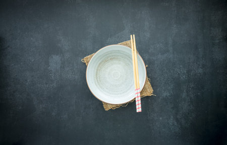 blank white ceramic bowl with wooden chopsticks on dark blue background, food and drink, dining...