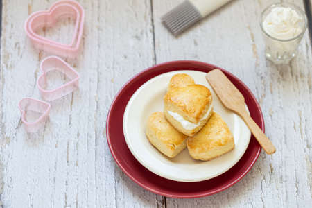 homemade plain scones arranged on dish with fresh cream for tea breakの写真素材