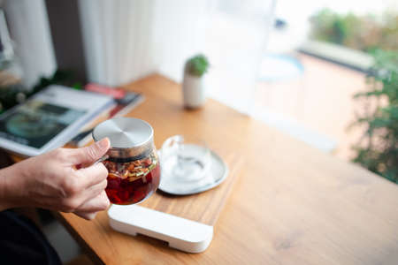 woman hand holding tea pot in cafe, afternoon tea breakの写真素材