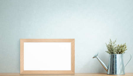 dried flower pot with photo frame decorated on wooden shelf or counter with light gray wall background and copy space, home decorの写真素材