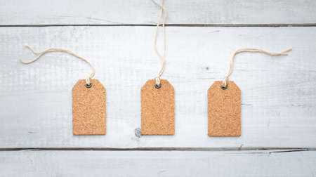 three blank corkboard tags isolated on white wood texture backgroundの写真素材