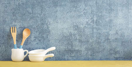kitchenware and utensils decorated on yellow shelf or counter with blue wall background and copy space, home decorの写真素材
