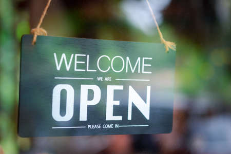 closeup open sign hanging on glass doorの写真素材