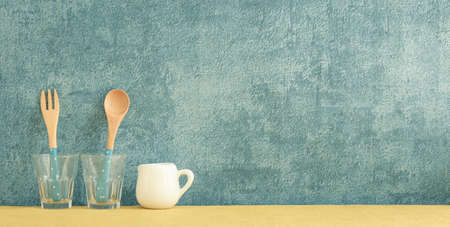 kitchenware and utensils decorated on yellow shelf or counter with blue wall background and copy space, home decorの写真素材
