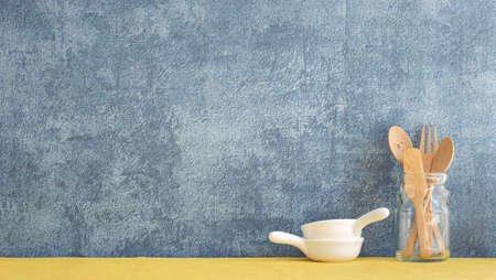kitchenware and utensils decorated on yellow shelf or counter with blue wall background and copy space, home decorの写真素材