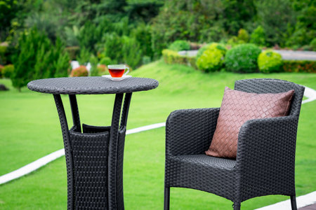 closeup set of outdoor table and chair with hot tea in green gardenの写真素材