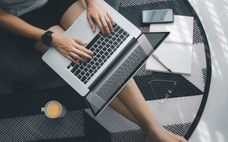 top view part of woman sit on floor with laptop while working at home during covid-19, work from home conceptの写真素材