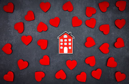 home model among red hearts spread on dark grey background, Valentine's day conceptの写真素材