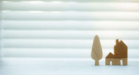 wooden home and tree model with bamboo blind on background, investment and insurance conceptの写真素材