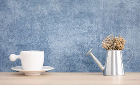dried flower pot and cup decorated on wooden shelf or counter with blue wall background and copy space, home decorの写真素材