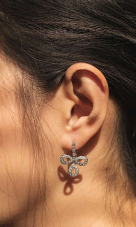 closeup woman ear with beautiful white gold diamond earringの写真素材