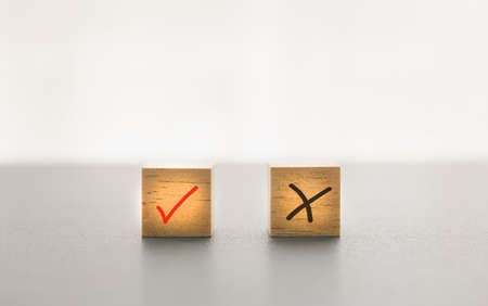check mark on wooden cubes with white background, right or wrong, do or don'tの写真素材