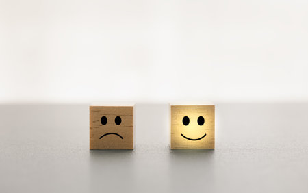different emotion faces on wooden cube with white background for satisfaction survey, mental health assessmentの写真素材