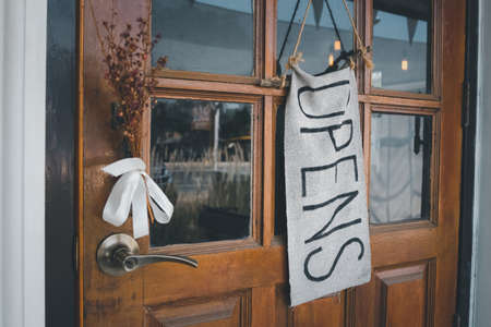 closeup handmade open sign hanging on wooden doorの写真素材