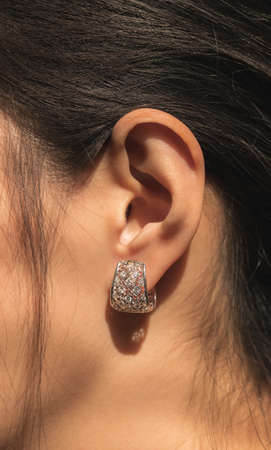 closeup woman ear with beautiful white gold diamond earringの写真素材