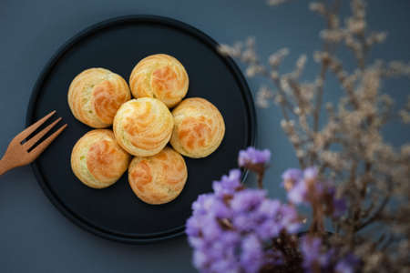 top view homemade mini choux cream or eclair filled with pandan custard served on black plateの写真素材