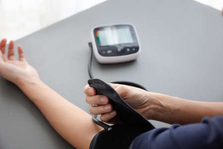 self blood pressure and heart rate measurement with blood pressure monitor machine, healthcare and medical conceptの写真素材
