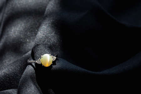 white gold ring with cats eye stone and diamond isolated on black background, fashion and design accessoryの写真素材