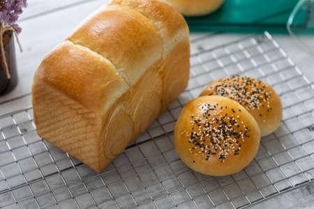 fresh baked milk bread loaf and burger buns on rack, homemade bakeの写真素材