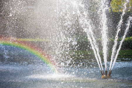 closeup fountain in lake with rainbowの写真素材