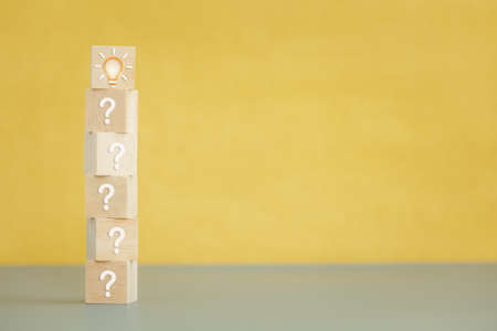 wood cube stack with question mark and light bulb icon on top, thinking and idea conceptの写真素材