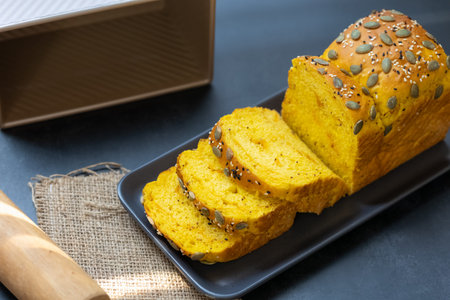 top view pumpkin bread loaf sliced on black dish