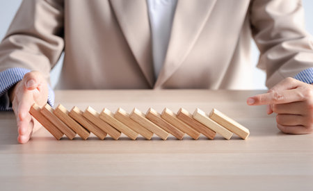 wood block row fallen by woman finger on wood table, business concept