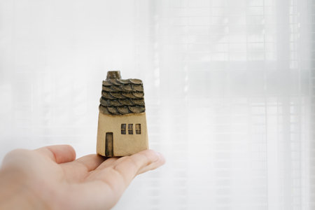 woman holding home model on hand, investment conceptの写真素材