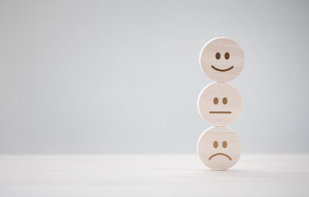 closeup stack of round wooden piece with various emotion face for satisfaction survey, mental health assessmentの写真素材