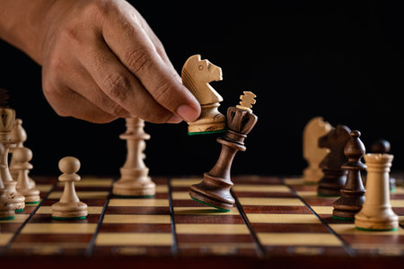 man hand playing chess on checkerboard, concept for business competitionの写真素材