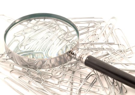 Magnifying glass on paperclips on white backgroundの写真素材