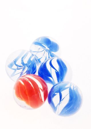 glassmarbles, four blue and one red on a white backgroundの写真素材