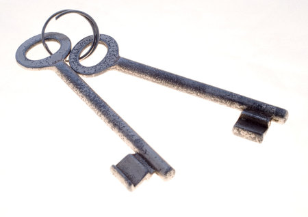 Two battered keys on a ring over a white background