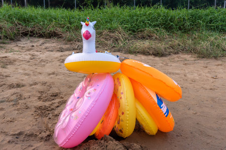 Coloful inflatable swimming ring with cute cartoon patterns on the beach in summer. Cute unicorn...