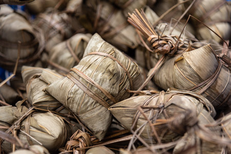 Zongzi, traditional Chinese food eaten during Dragon Boat Festival. Glutinous rice dumpling. A Chinese delicacy made of glutinous rice wrapped in reed leaves with various fillings.の写真素材