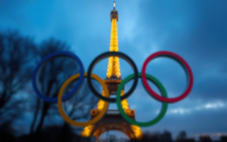 Olympic rings shine in front of the illuminated Eiffel Tower during a twilight event in Parisの素材