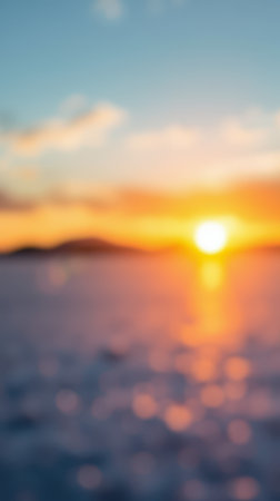 Beautiful sunset over the ocean creating a serene atmosphere with warm colors and blurred reflections in the waterの素材